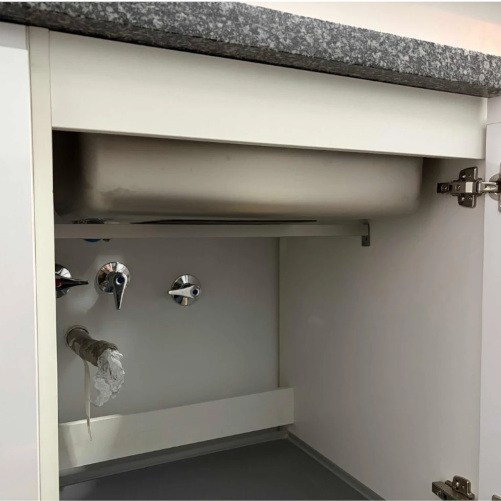Barra de refuerzo de aluminio de 2x2 cm instalada bajo un fregadero de cocina.
